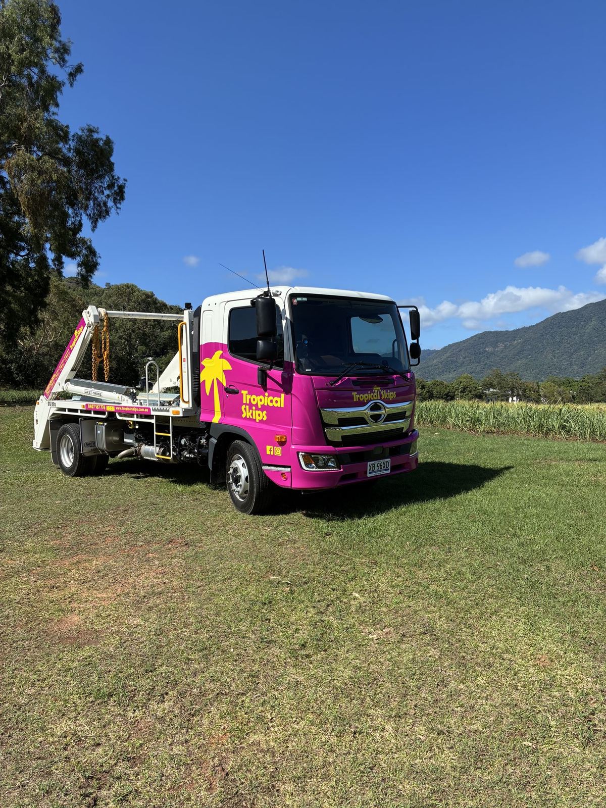 Tropical Skips truck on grass with the ranges behind