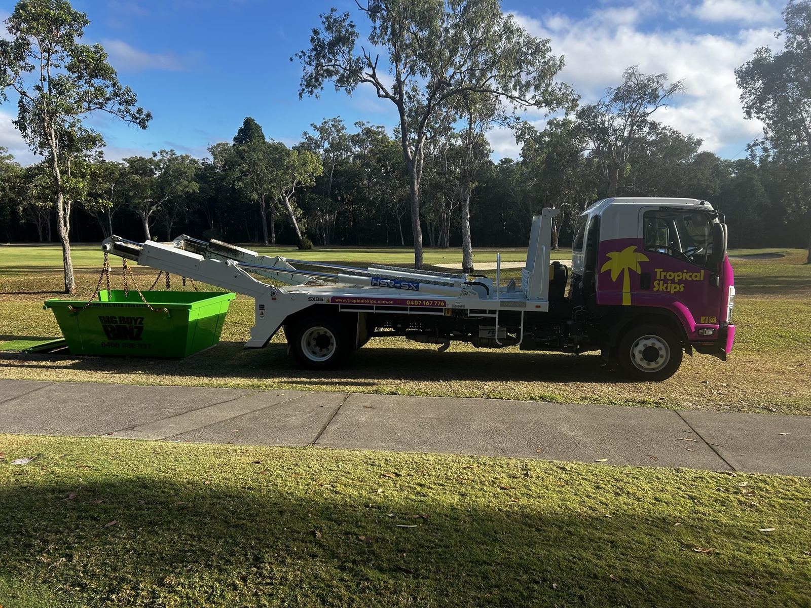 Tropical Skips truck with green skip bins beside a Cairns park