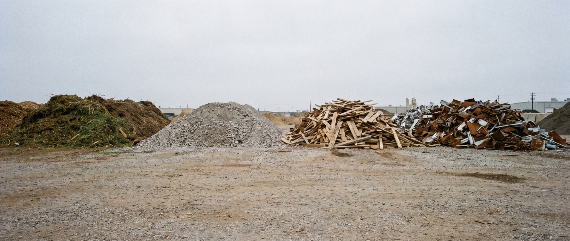 Sorted stockpiles of green waste, concrete and timber at a Cairns sorting pad